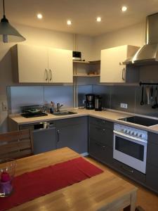 a kitchen with white cabinets and a wooden table at Ferienwohnungen Martensstrasse in Gersfeld