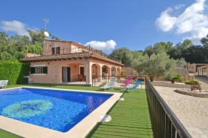 a villa with a swimming pool in front of a house at Villa Victori in Sineu