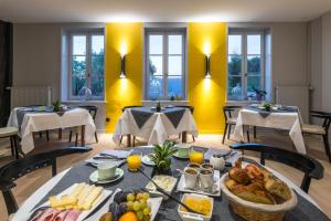 a dining room with a table filled with food at Le Moulin du Gastronome in Charnay-lès-Mâcon