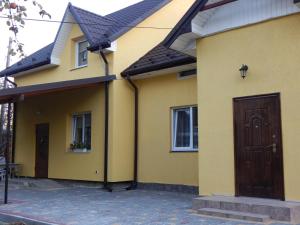 a yellow house with a brown door and windows at Sweet Apartment in Truskavets