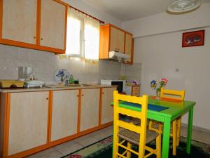 a kitchen with a green table and yellow chairs at Small studio near the center of Tripoli in Tripoli