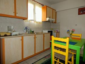 a kitchen with a green table and yellow chairs at Small studio near the center of Tripoli in Tripoli
