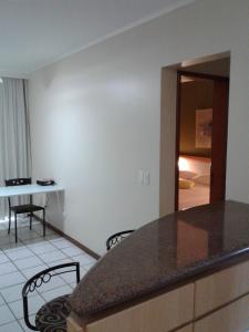 a kitchen with a counter and a table and chairs at Apart Quartier Latin in Vitória