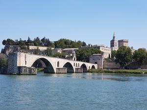 a bridge over a river with a city in the background at chambre cocoon in Roquemaure