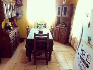 a kitchen with a table and chairs and a refrigerator at Cabañas de Campo in Santa María +7 photos