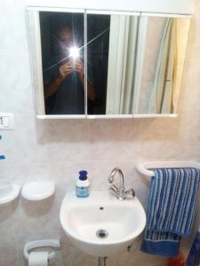 a person taking a picture of a sink in a bathroom at Casa Teatro Greco in Catania