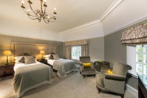 a hotel room with two beds and a chandelier at Piersland House in Troon