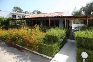 a garden with flowers in front of a house at Despina Hotel in Afantou