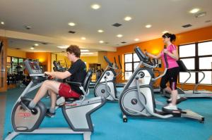 two people riding on exercise bikes in a gym at Westport Woods Hotel & Spa in Westport
