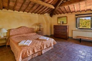 Un dormitorio con una cama y una cómoda y una ventana. en Casale il Gualdo by VacaVilla, en Radda in Chianti
