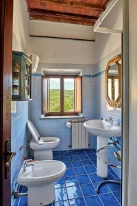 Baño de azulejos azules con 2 lavabos y espejo en Casale il Gualdo by VacaVilla, en Radda in Chianti 46 fotos más