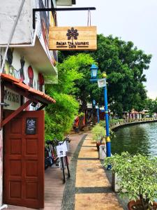 um edifício com uma porta vermelha ao lado de um rio em Relish The Moment em Malaca