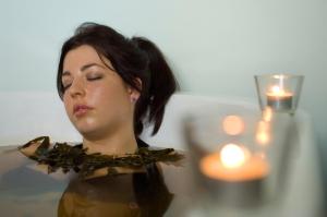 a woman with her eyes closed next to a candle at Westport Woods Hotel & Spa in Westport