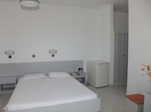 a white bedroom with a large white bed in it at Despina Hotel in Afantou