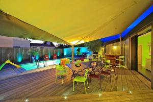 a patio with a table and chairs and a pool at La Chaize - Villa, Suites & Spa in Noirmoutier-en-l'lle +13 photos