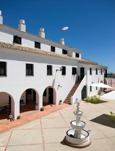 a kite flying over a white building with a fountain at Albergue Inturjoven Punta Umbría in Punta Umbría