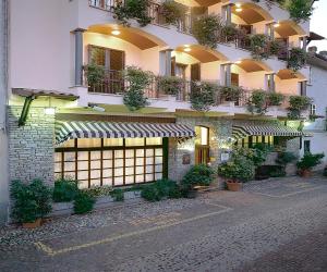 a building with potted plants on the side of it at Hotel Ristorante Al Sorriso in Soriso