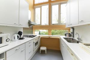 a kitchen with white cabinets and a sink at Superior, 100m2 in Amsterdam