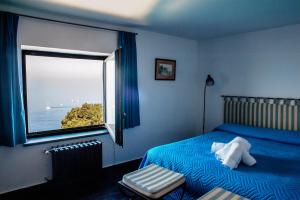 a bedroom with a bed and a window with a view at Villa Margi in Vico Equense