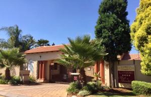 a building with palm trees in front of it at Le Cozmo Guesthouse in Johannesburg
