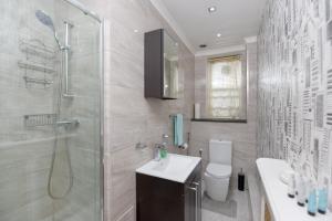 een badkamer met een douche, een wastafel en een toilet bij Gloucester Gardens in Londen
