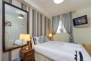 ein Schlafzimmer mit einem großen Bett und einem Spiegel in der Unterkunft Gloucester Gardens in London