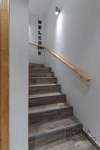 a staircase with white walls and wood floors at The Carpenter´s Boutique Apartments in Marbella