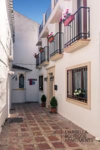 een binnenplaats van een gebouw met balkons en potplanten bij The Carpenter´s Boutique Apartments in Marbella