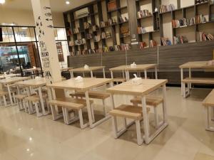 a row of tables and chairs in a restaurant at Arya Inn in Pematangsiantar