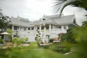 a large white house with a garden in front of it at NirvaNAN House in Nan