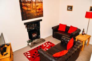 a living room with a couch and a fireplace at Aqueduct Cottage in Llanover