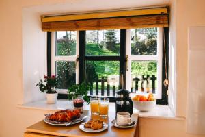 ein Tisch mit zwei Tellern Essen und einem Fenster in der Unterkunft Aqueduct Cottage in Llanover