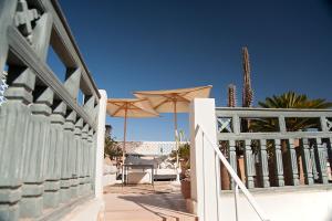 una recinzione bianca con ombrelloni su un patio di Riad Le J a Marrakech