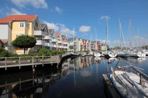 a group of boats docked in a marina with houses at Ferienwohnungen Am Yachthafen in Greifswald