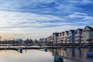 una fila de edificios de apartamentos junto a una masa de agua en Ferienwohnungen Am Yachthafen, en Greifswald