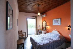 a bedroom with a bed in a room with orange walls at Paradise Hotel in Patitiri +19 photos