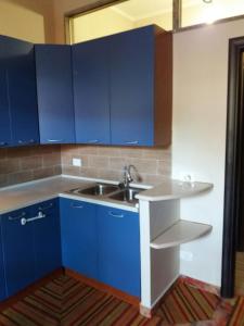 a kitchen with blue cabinets and a sink at Appartamenti Villa Wanda in Palmi