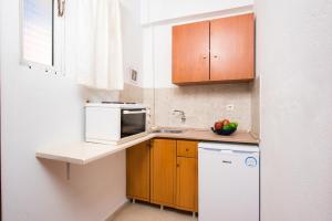 a small kitchen with a sink and a microwave at Kavos Fantasia Complex in Kavos