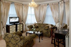 - un salon avec un canapé et une table dans l'établissement Stags Head Hotel, à Bowness-on-Windermere