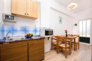 a kitchen with a sink and a table with a microwave at Kavos Fantasia Complex in Kavos