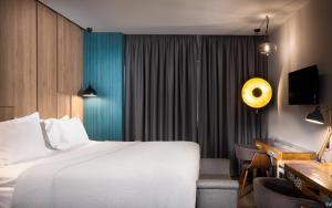 a hotel room with a white bed and a desk at 360Degrees Pop Art Hotel in Athens +128 photos