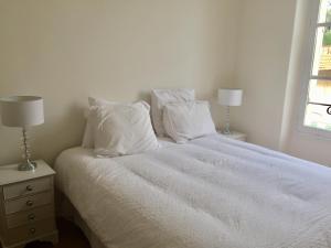 カンヌにあるPalais Bellevueのベッドルーム1室(白いベッド1台、枕付)、窓が備わります。