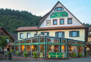 um grande edifício com um restaurante em frente em Hotel Freihof em Oberharmersbach