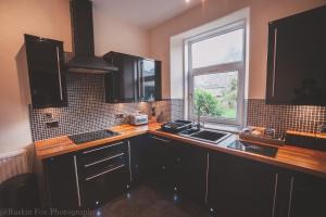 une cuisine avec un comptoir, un évier et une fenêtre dans l'établissement Stylish and Spacious two bed in Aberdeen's West End, à Aberdeen