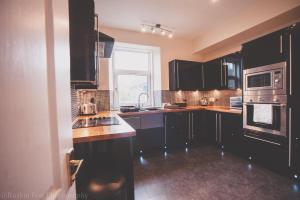 a kitchen with black cabinets and a window at Stylish and Spacious two bed in Aberdeen's West End in Aberdeen