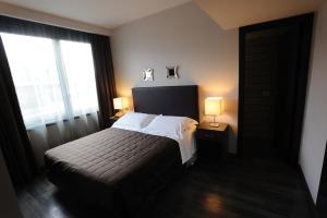 a bedroom with a bed with two lamps and two windows at Park Hotel Sporting in Teramo