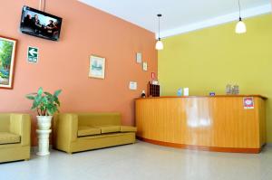 a waiting room with two yellow chairs and a counter at Primavera Plaza Hotel in Tacna