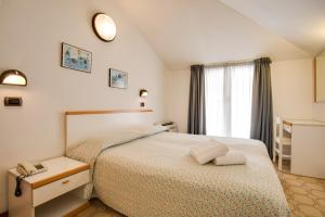Postel nebo postele na pokoji v ubytování Hotel Villa dei Gerani + 37 fotografií