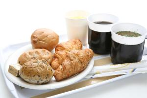 a plate of food with rolls and two cups of coffee at Hotel Select Inn Nagano in Nagano