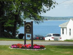 a sign on the side of a road with flowers at Bar Harbor Cottages & Suites in Bar Harbor